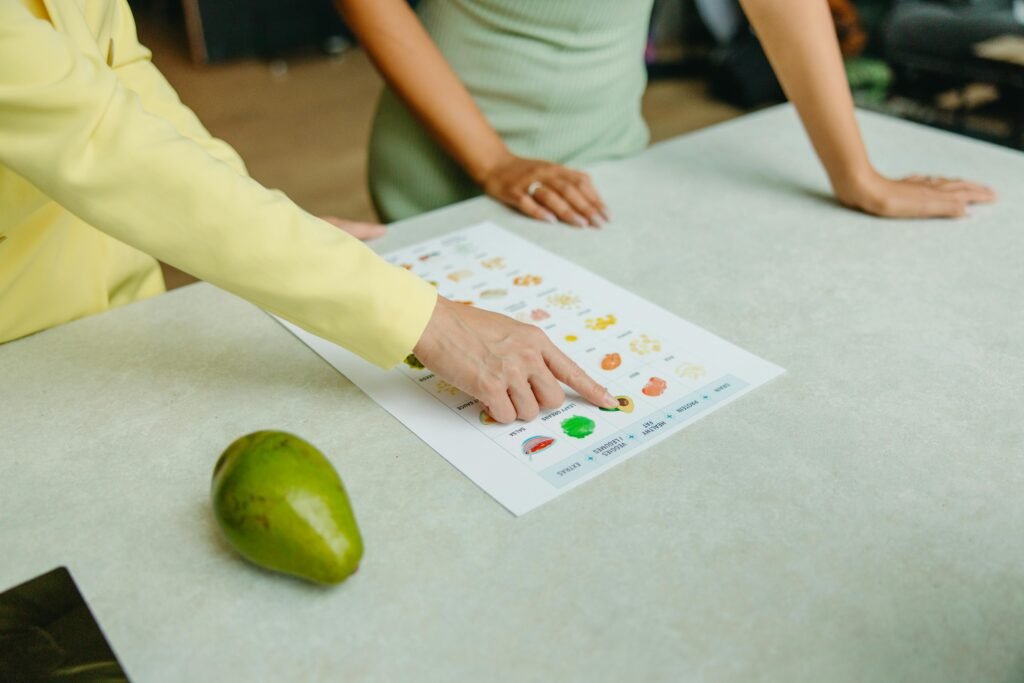pexels photo 8844379 8844379 Two adults discussing food options with a chart, highlighting healthy nutrition indoors.